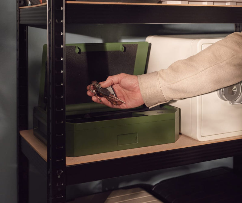 Hand Holding Keys with Case Safe Open in Garage