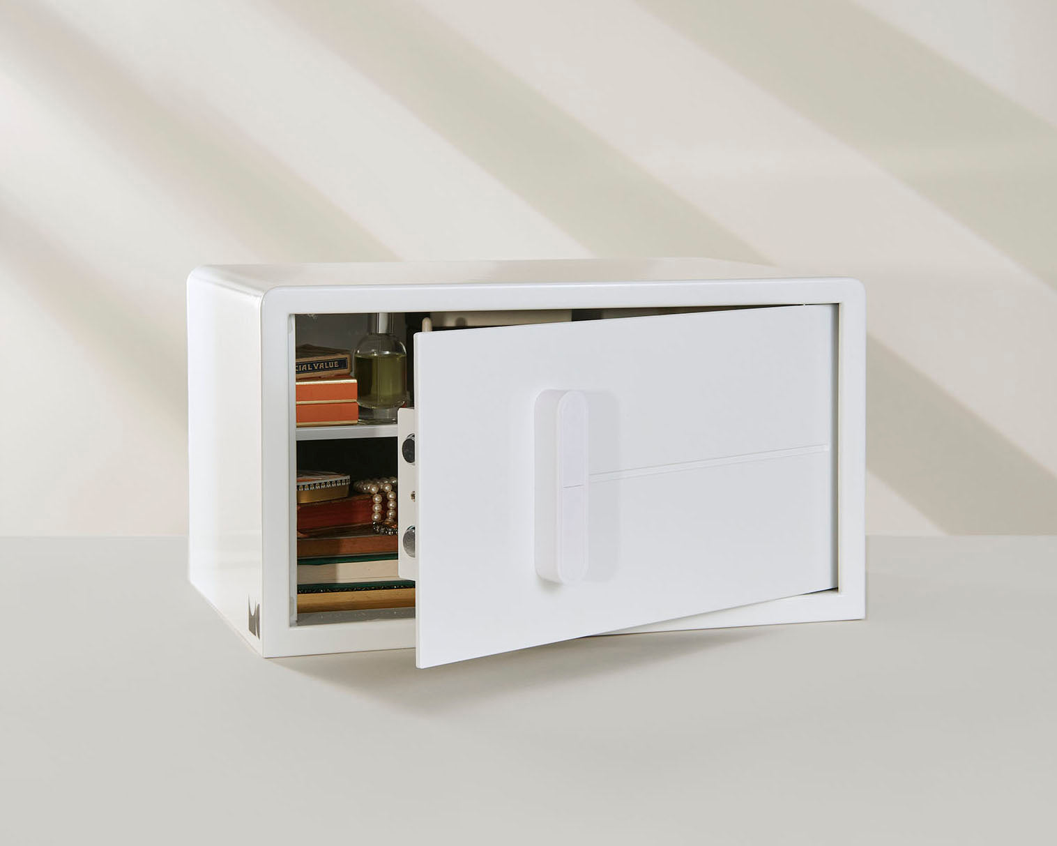 An angled image of the white iCube with the door slightly open to show jewelry and other objects inside it