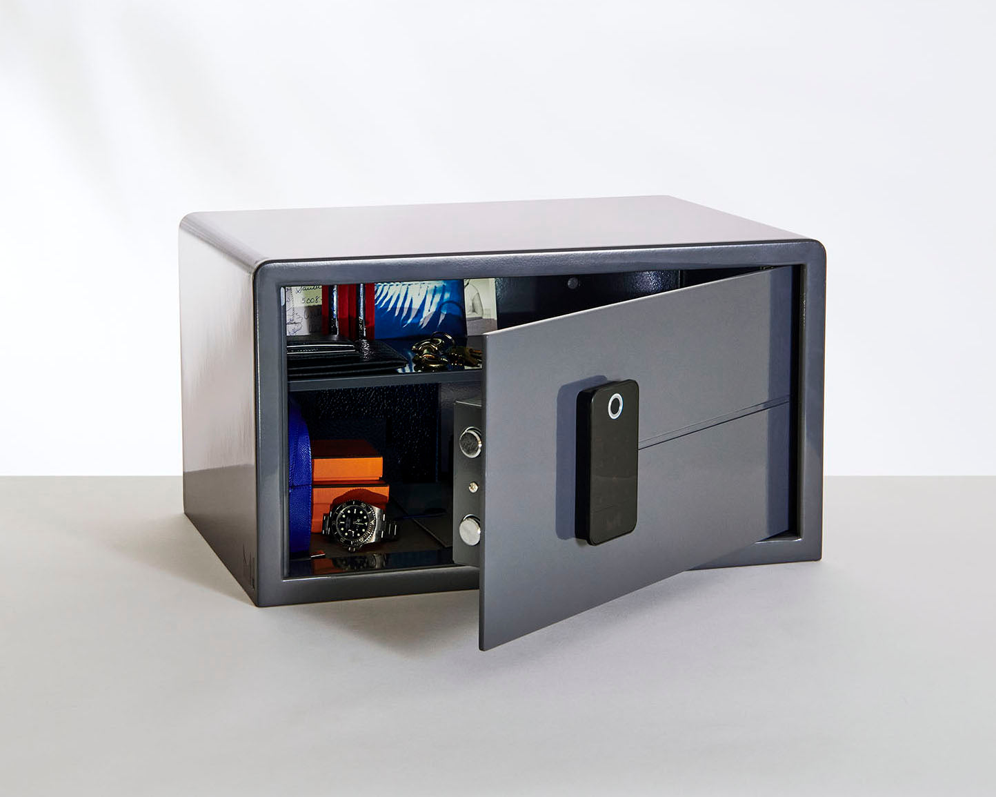 An opened Biocube graphite grey safe showing personal belongings