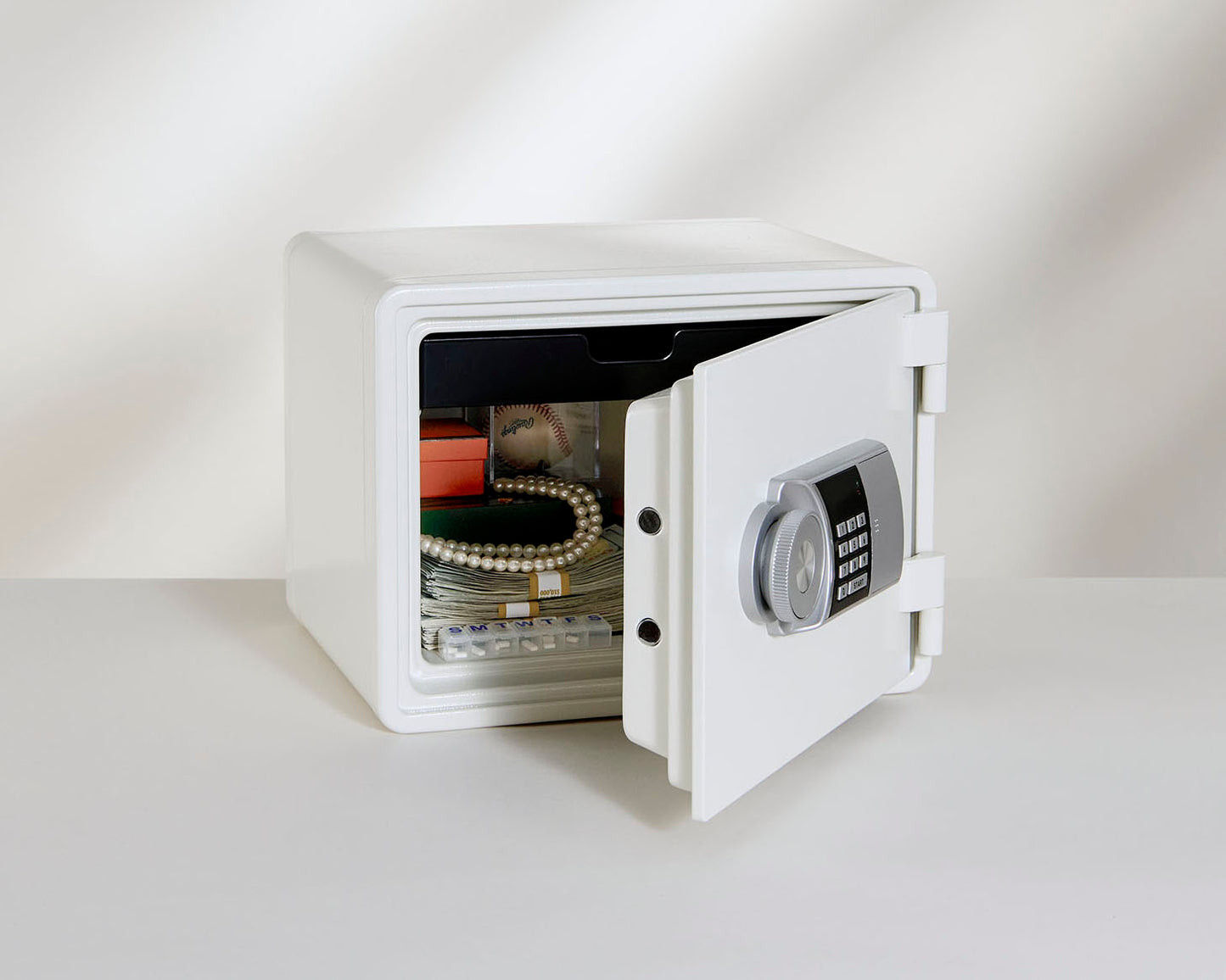 A white Mycube Fire with the door slightly open to show jewelry and documents within the safe