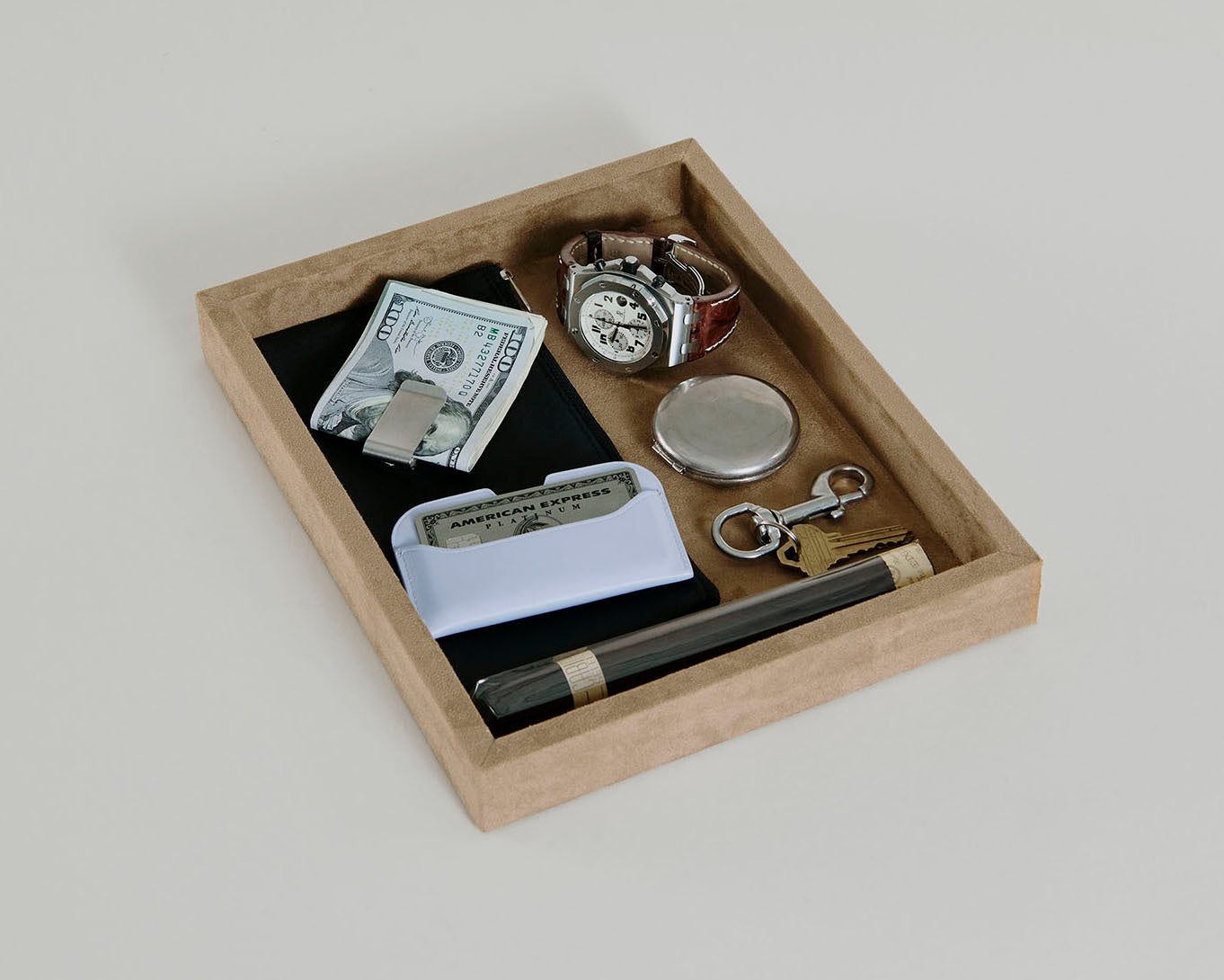 Beige Single Space Tray with jewelry, money, and a cigar sitting within it
