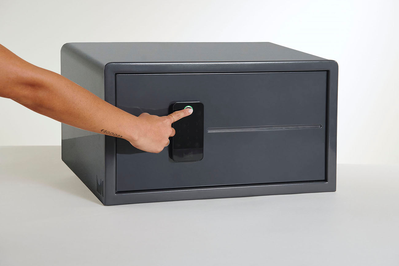 A person using their index finger on a Biocube biometric pad to unlock it