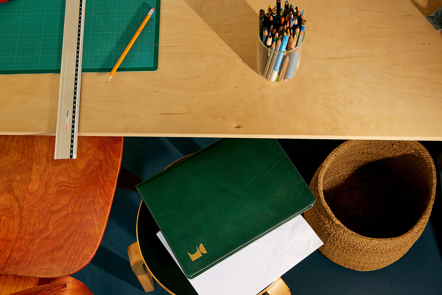 Laid out green leather document folio in office 