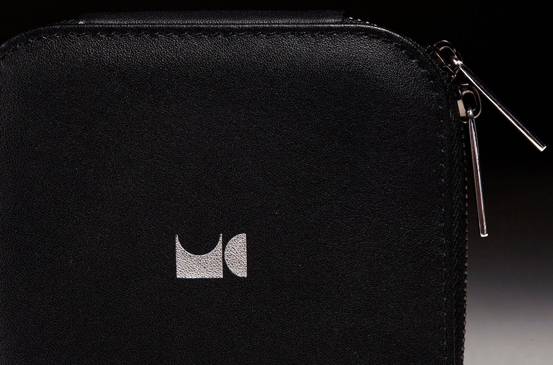 Close up view of jewelry case zippers in front of a black back drop